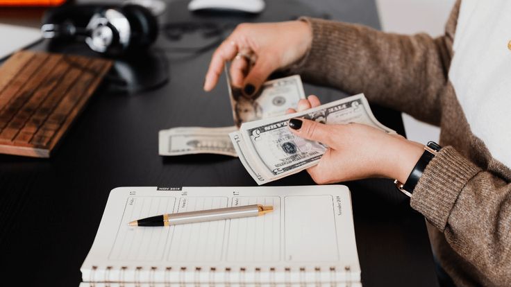 Manos de una persona contando billetes y administrando dinero
